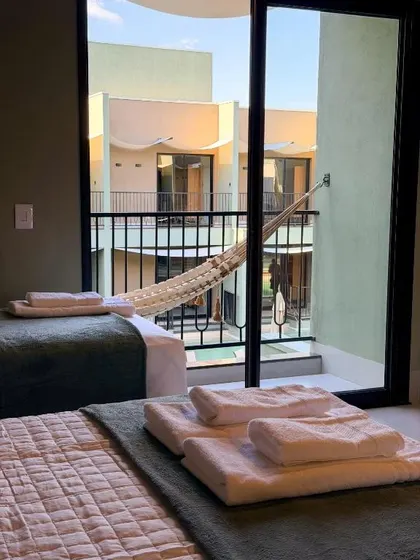 Toalhas na cama e rede na varanda